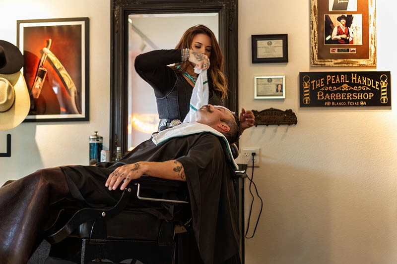 blanco-tx-barber-gallery6 Picture of Aimee placing hot towel on client
